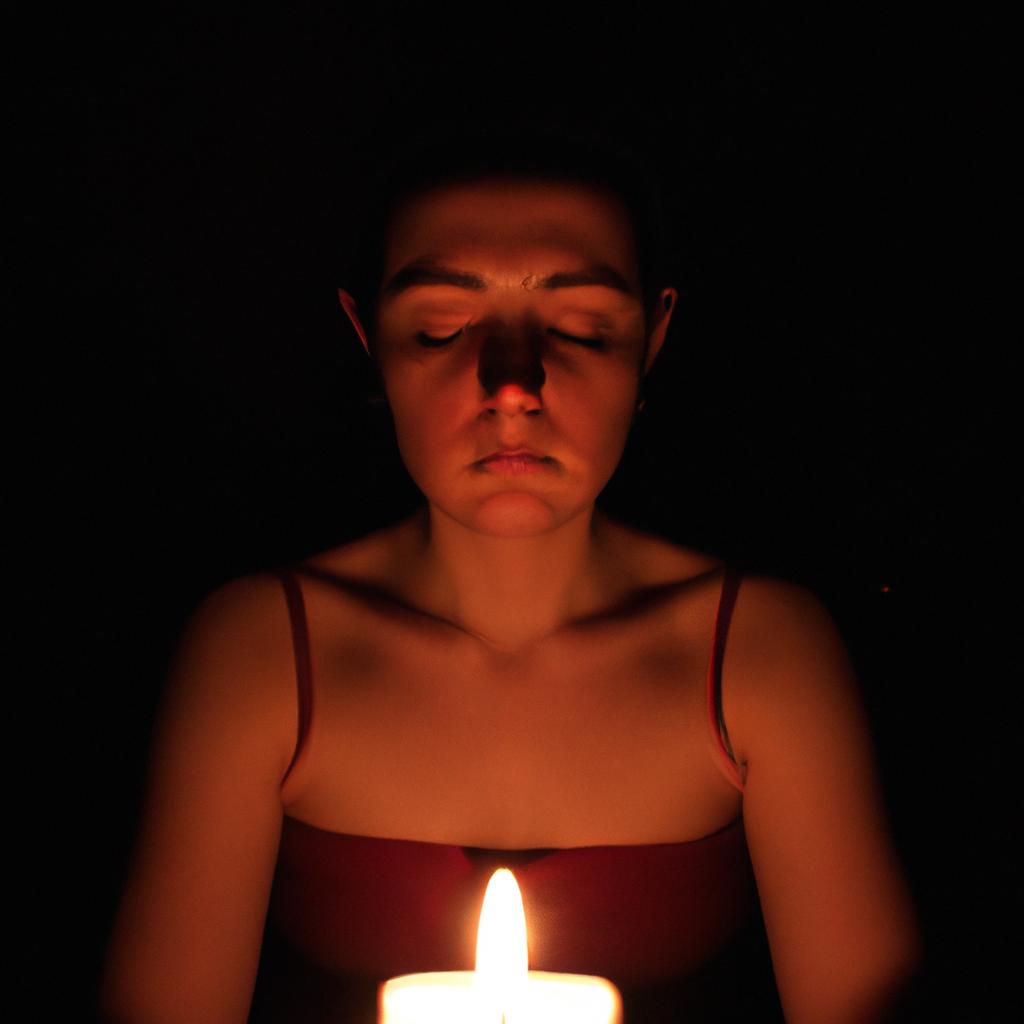 Person meditating in candlelight